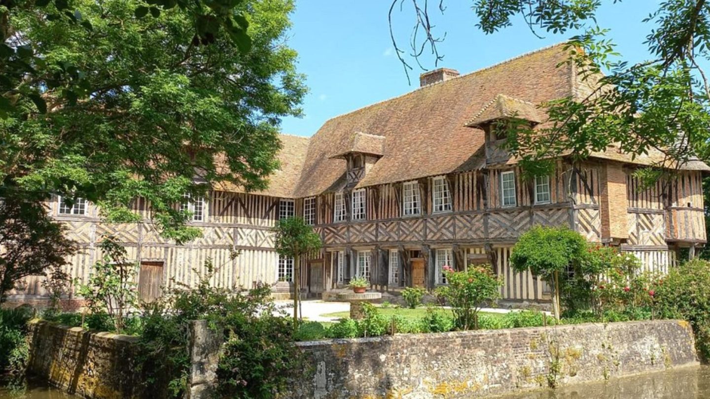 Le manoir de Coupesarte et ses douves, vue générale depuis le chemin.